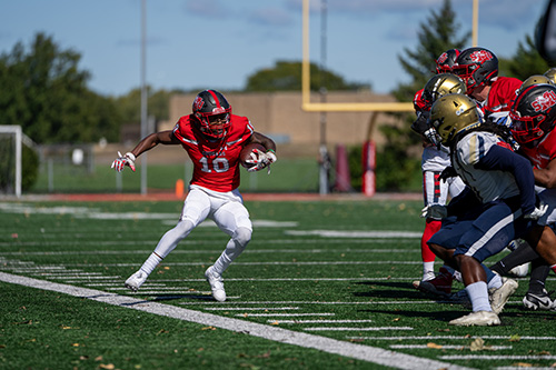 SXU football player juking near the sidelines