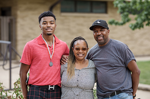 New SXU smiling with parents by their sides