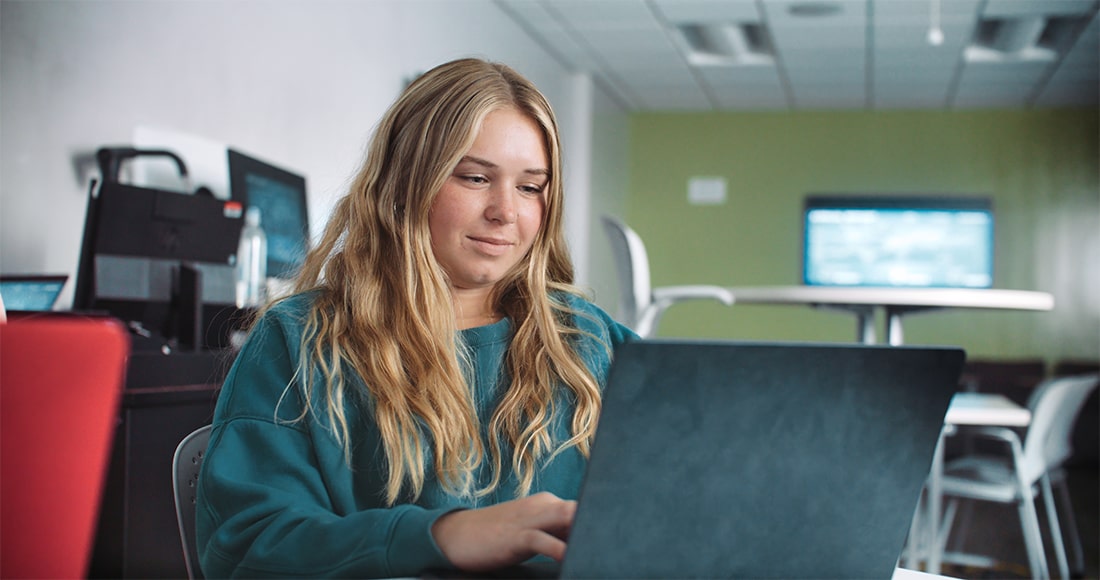 Girl working on laptop in class